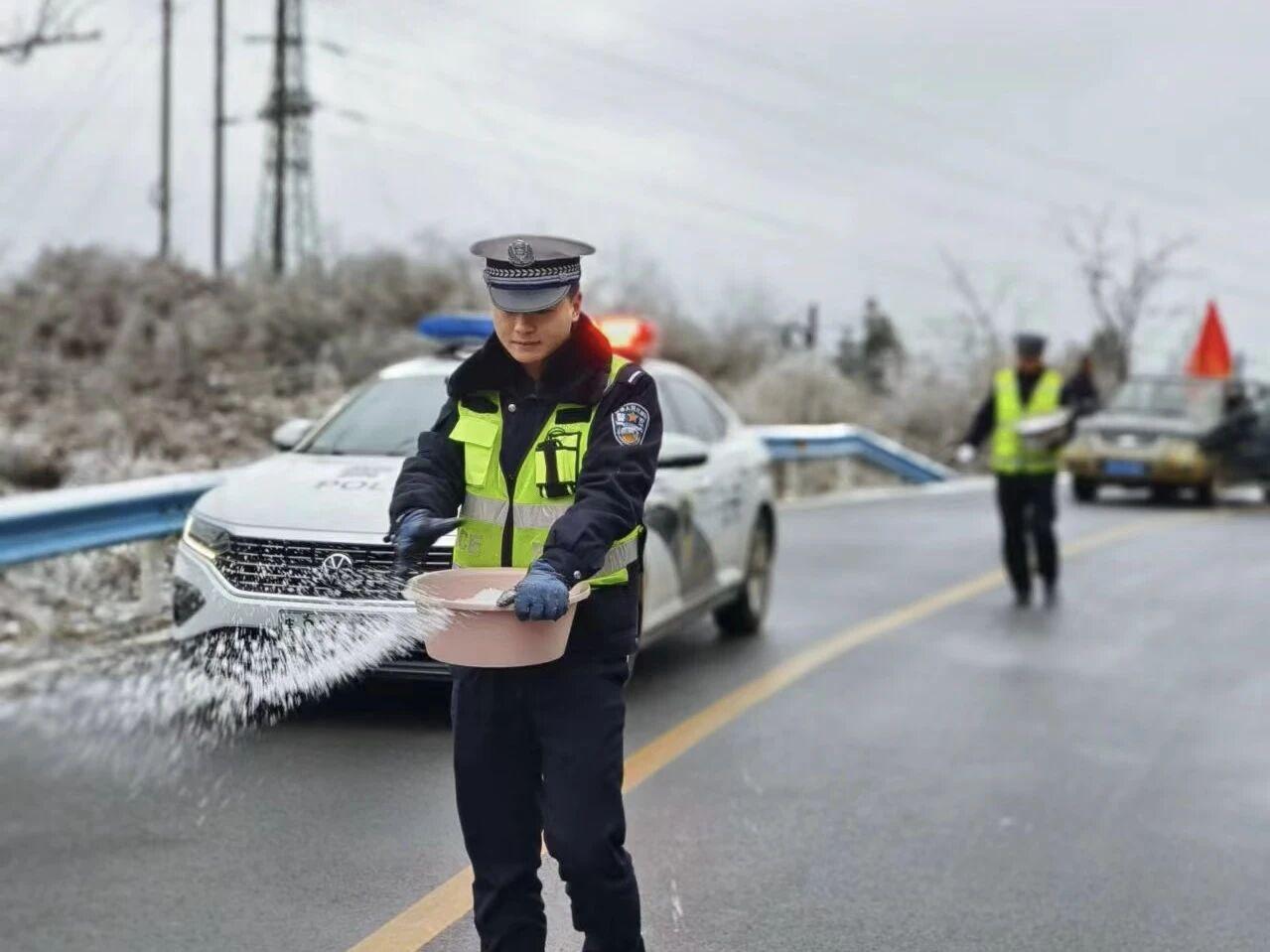 圖1民警在轄區(qū)結冰路段開展撒鹽除冰防凍工作。.jpg