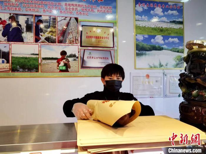 圖為鄭繼梅正在打包烤鵝?！≈x宏秀供圖