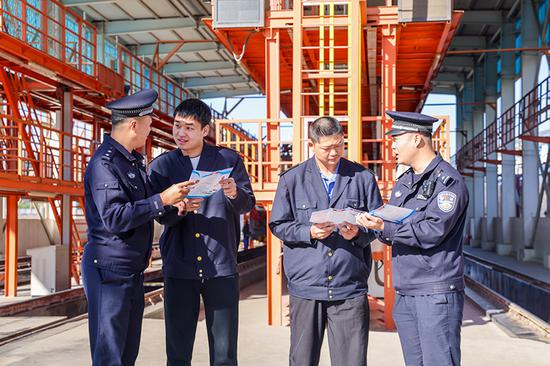 刑警支隊民警向企業(yè)職工發(fā)放宣傳資料并“一對一”講解電詐常識。謝仁古力·托呼提 攝